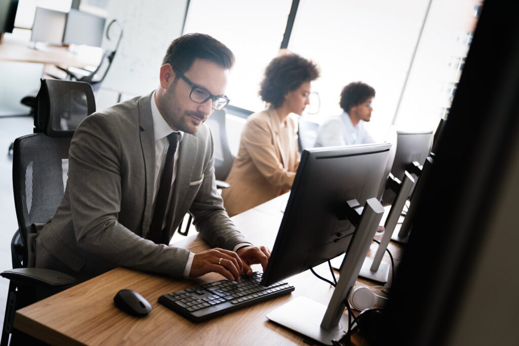 homme qui travaille sur un ordinateur dans un open space avec une posture droite