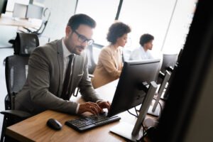 homme qui travaille sur un ordinateur dans un open space avec une posture droite