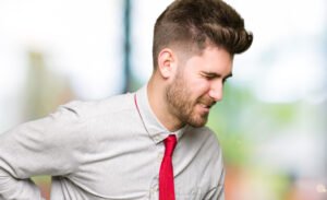 homme jeune semblant etre fatigué et avoir mal au dos